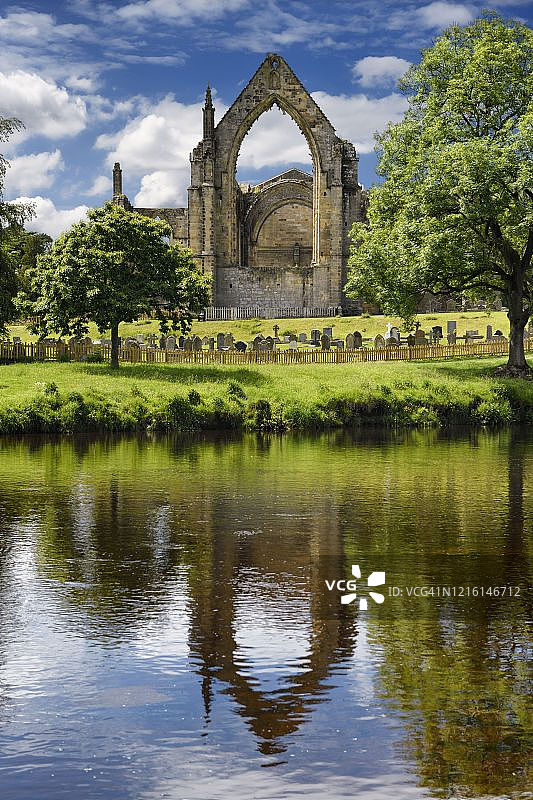 12世纪奥古斯丁博尔顿修道院教堂遗址倒映在北约克郡博尔顿修道院沃夫河中图片素材
