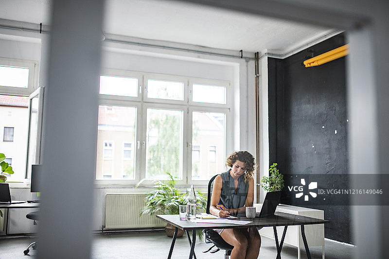 在现代开放式办公空间工作的年轻女商人图片素材