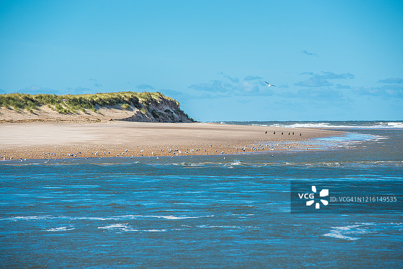 从霍克姆海滩隔着狭窄的伯恩河口看到的斯科尔特海角岛国家自然保护区。诺福克北部海岸。东安格利亚。英国。图片素材