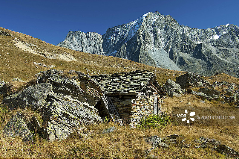 瑞士瓦莱州阿罗拉，瓦尔德赫伦斯山谷的牧羊人石屋，后方是佩罗克峰图片素材