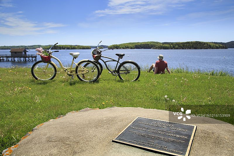 美国缅因州卡斯廷的佩诺布斯科特湾，夏季有两辆自行车和历史标记图片素材