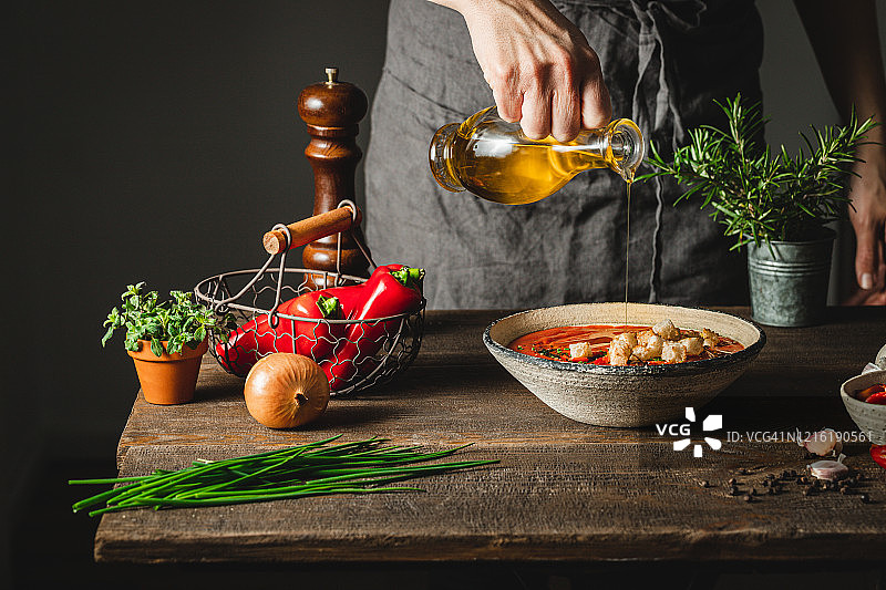 厨师在红椒汤锅中加入橄榄油图片素材
