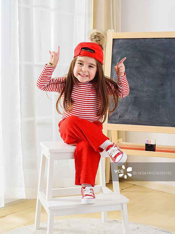 可爱的小女孩在黑板上画画图片素材
