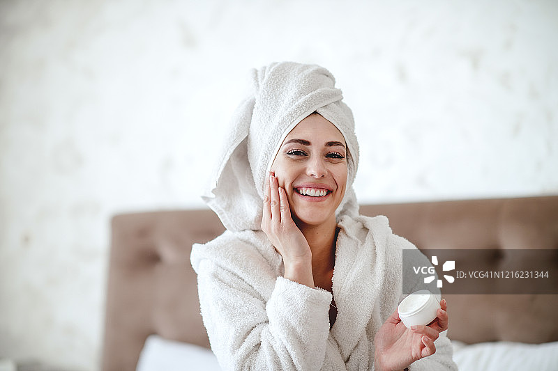 女子在脸上涂抹保湿霜图片素材