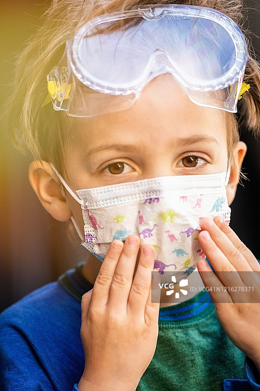 戴着防护口罩和防护眼镜摆姿势的白人男孩图片素材