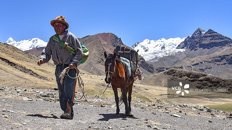 在秘鲁安第斯山脉，男人沿着小路牵着骡子，奥桑加特峰，库斯科，秘鲁图片素材