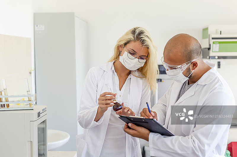 实验室工作人员讨论冠状病毒检测图片素材