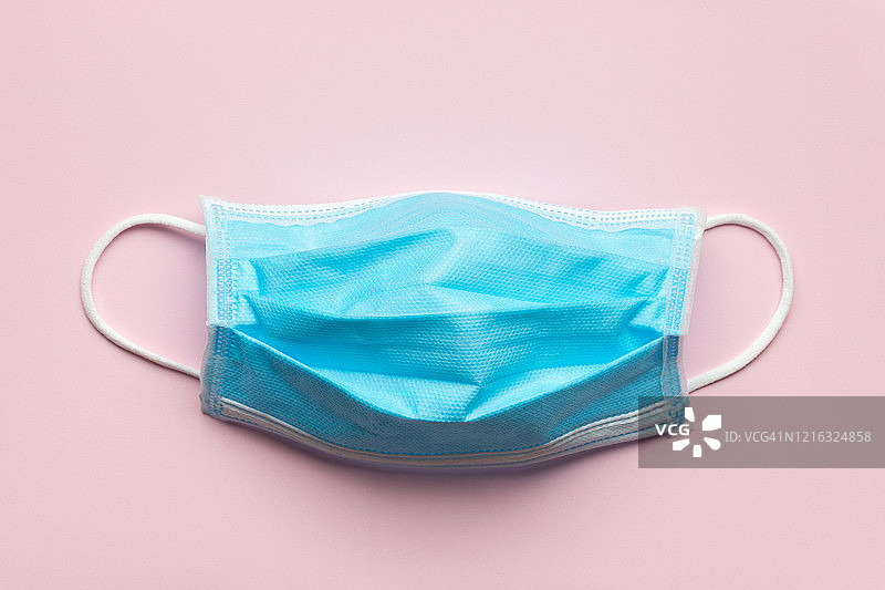 医疗防护：医生口罩与新冠病毒防护，浅粉色背景图片素材