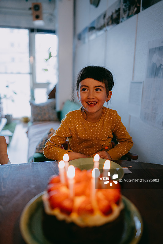 对生日蛋糕感到兴奋的可爱小女孩图片素材