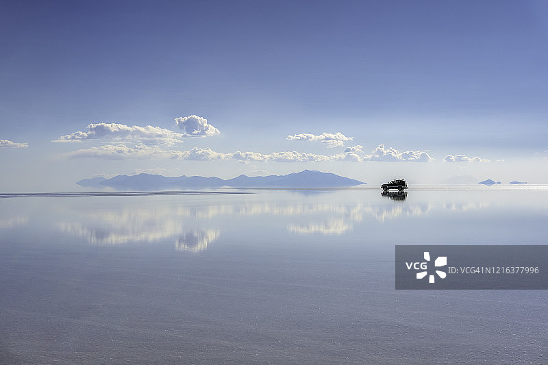 玻利维亚乌尤尼盐沼的云和越野车倒影图片素材