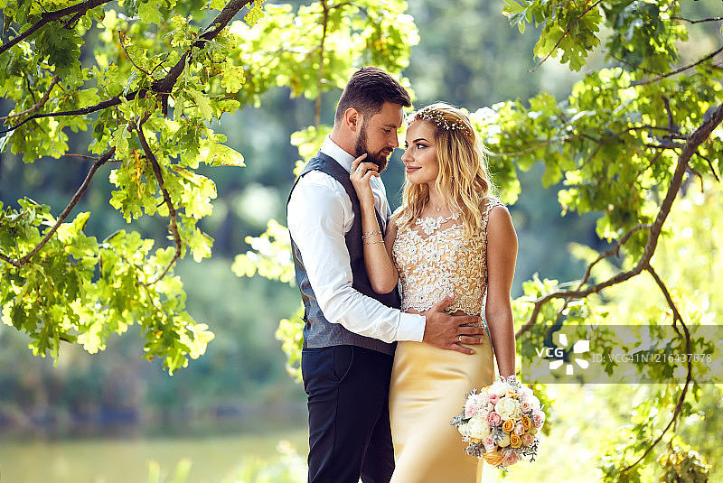 时尚的新婚夫妇在公园里摆姿势图片素材