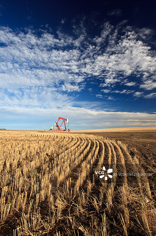 平原上的抽油机与壮丽的天空图片素材