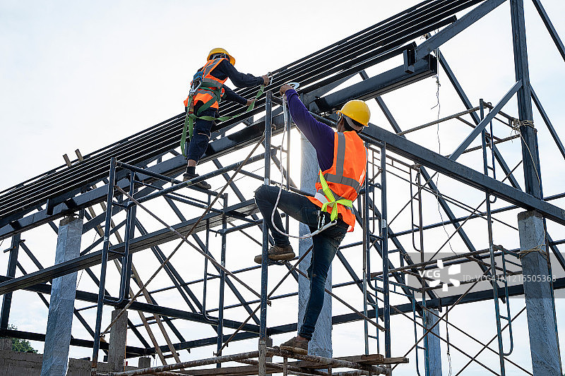 工程师和建筑团队在高层建筑的脚手架上安全工作，建设工程概念图片素材