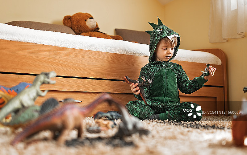 玩恐龙玩具的幼儿男孩图片素材