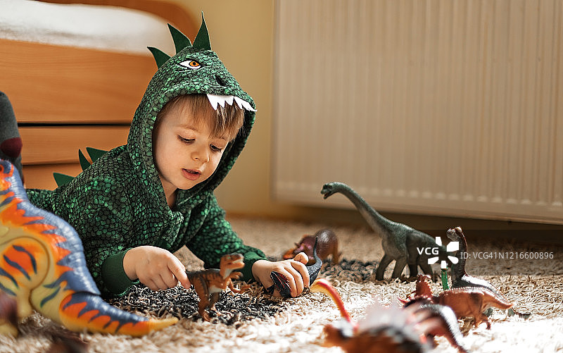 玩恐龙玩具的可爱男孩图片素材