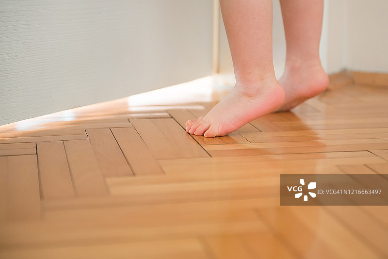 可爱的儿童脚丫，幼儿试图够到门把手图片素材