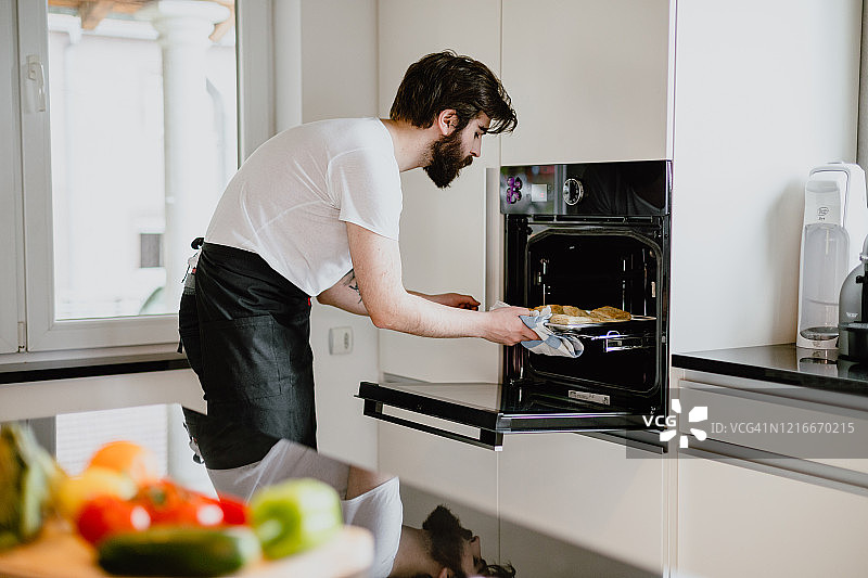 年轻男人在家中厨房烘焙糕点图片素材
