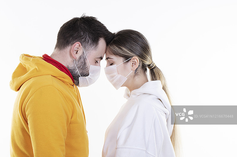 隔离期间戴口罩的情侣，零接触图片素材