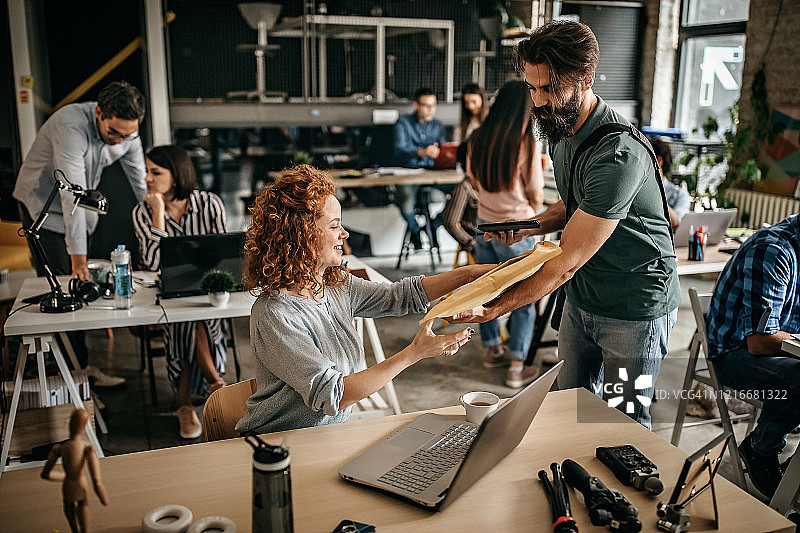 快递员向漂亮的办公室经理递送文件图片素材