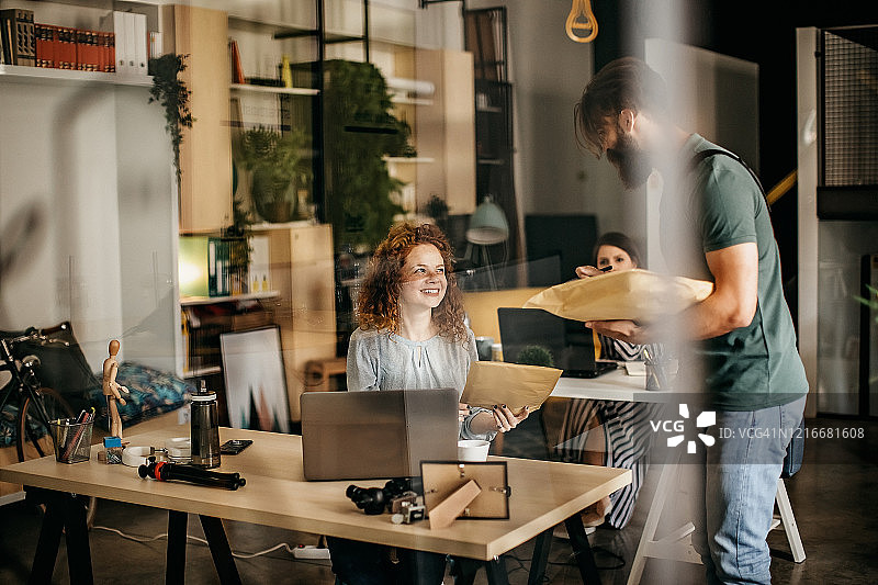 快递员向漂亮的办公室经理递送文件图片素材