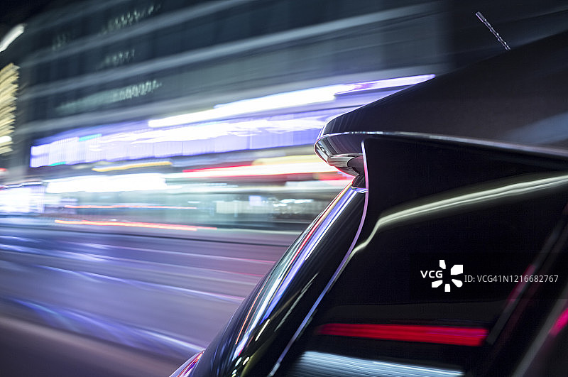 夜间城市中疾驰的可持续能源电动汽车图片素材