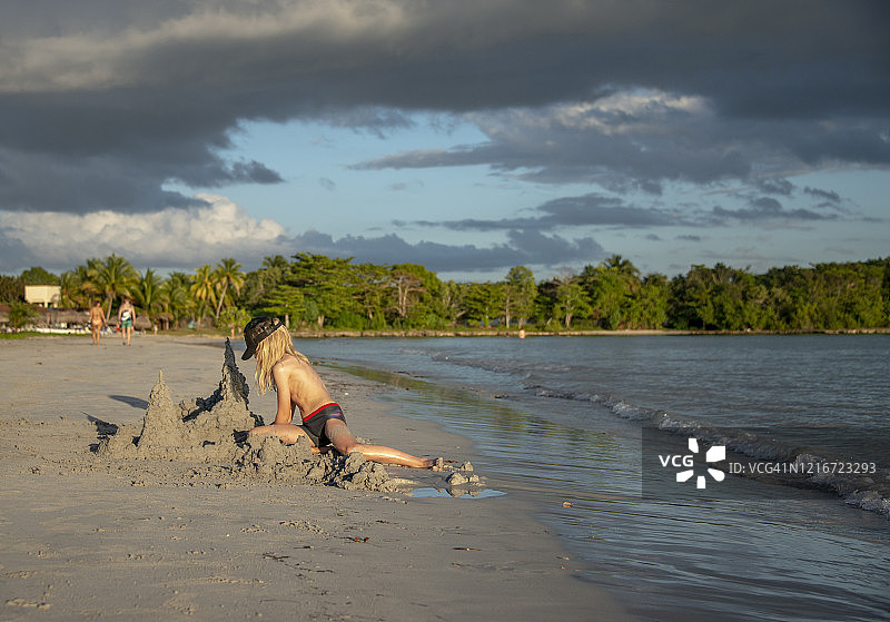 在古巴拉arga海滩堆沙堡的金发男孩图片素材