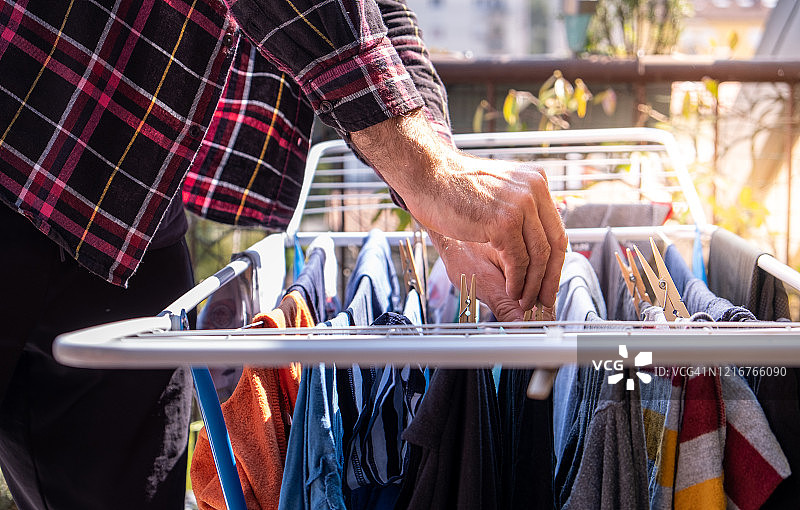 在户外晾衣绳上晾衣服的男人图片素材