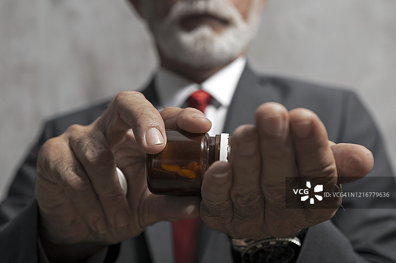 西装革履的年长男人和药丸图片素材