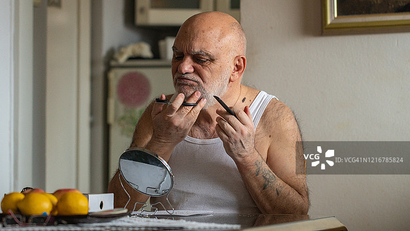 成年男子在家里客厅修剪胡须图片素材