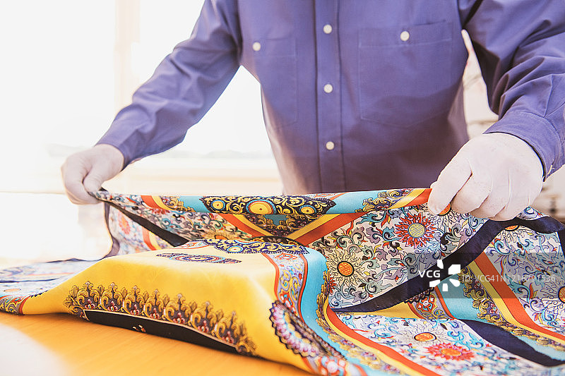 戴着口罩制作风吕敷的年长男人（隔离期间的复活节）图片素材