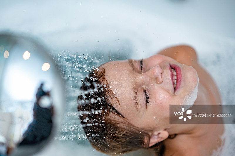 男孩在浴室里洗头图片素材