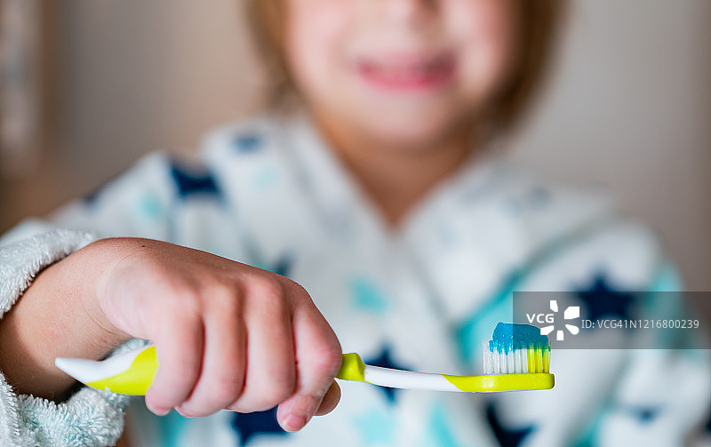 手持牙刷和牙膏的男孩特写图片素材