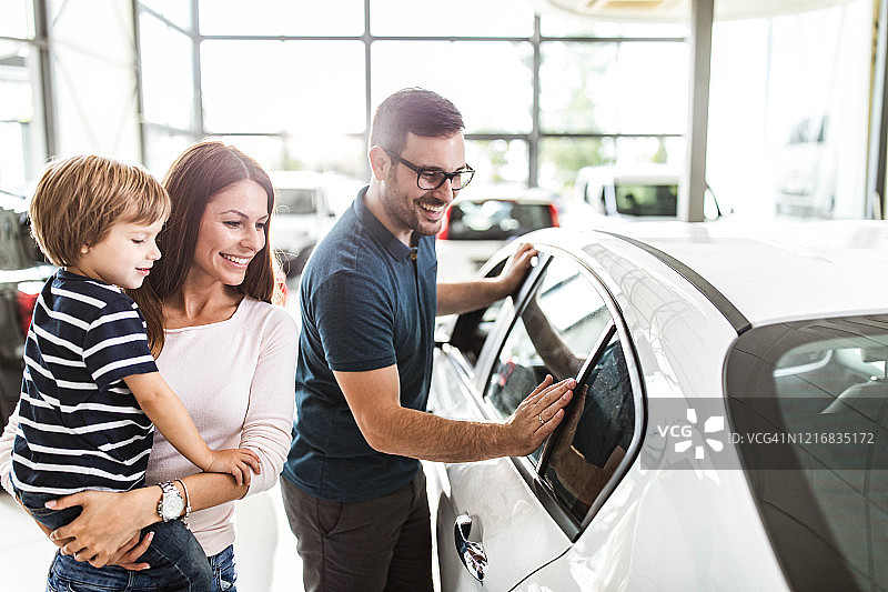 幸福的家庭在展厅里选择新车图片素材