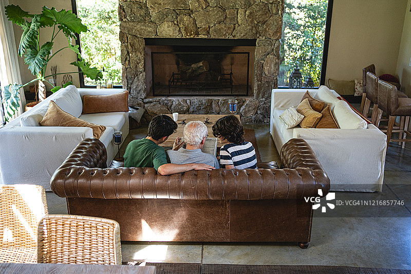 孙辈在沙发上放松时与祖父交谈图片素材