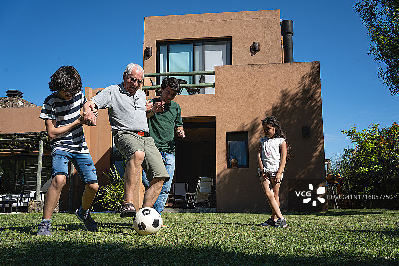 爷爷和孙子们一起踢足球图片素材