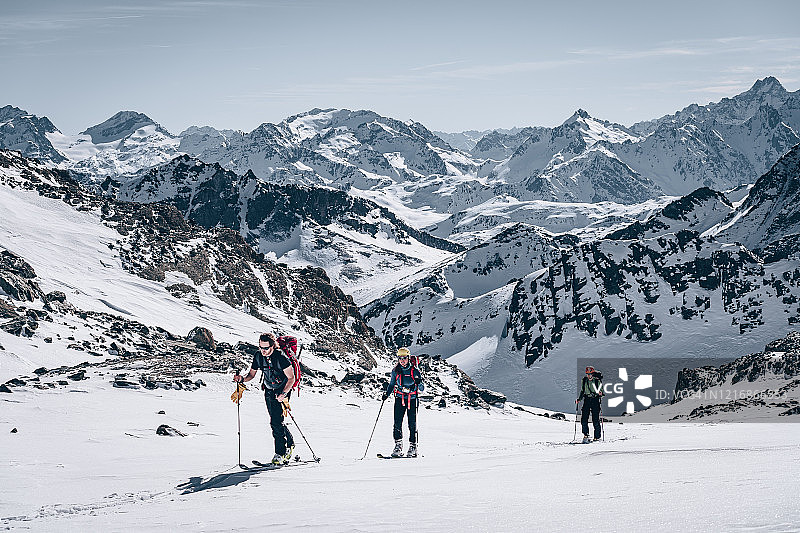 一群滑雪登山者在山坡上向上移动图片素材