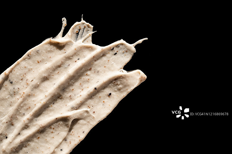 黑色背景下的化妆品磨砂膏质地，含咖啡和蜂蜜的面部和身体磨砂膏，有机美容概念图片素材