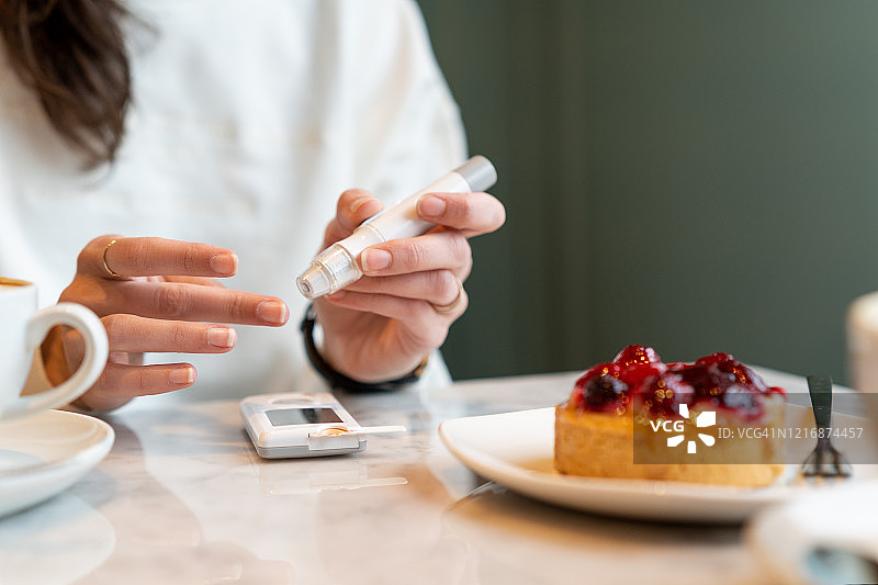 吃蛋糕前检查胰岛素水平的女人图片素材
