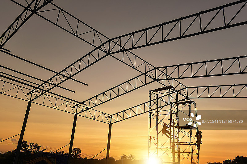 泰国建筑工地脚手架上建筑工人的剪影图片素材