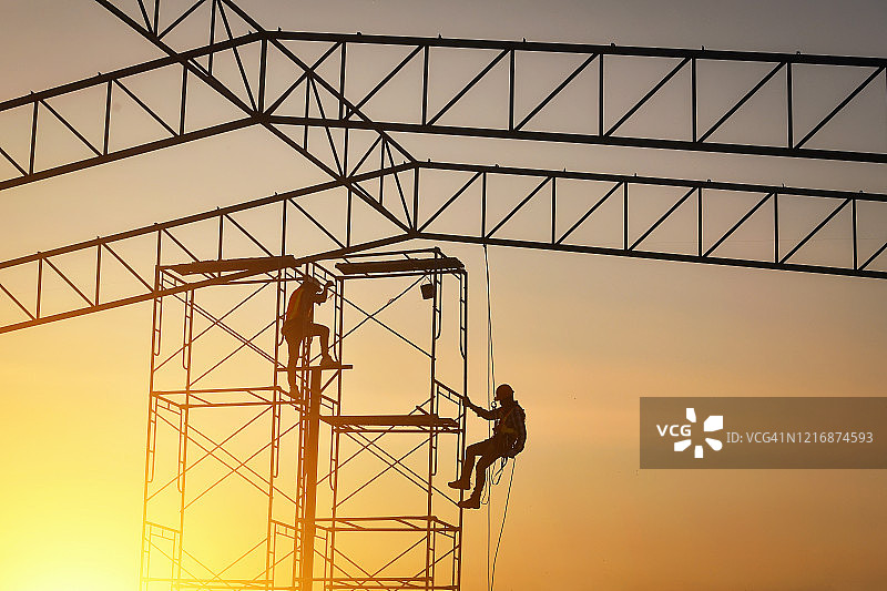 泰国建筑工地上的两名建筑工人剪影图片素材