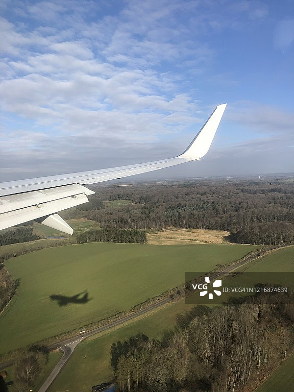 飞机机翼和飞机在日德兰半岛比隆附近乡村景观上空飞行的阴影图片素材