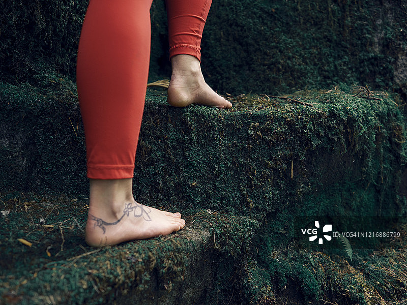 赤脚女人走上长满苔藓的天然阶梯图片素材