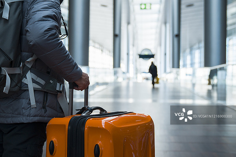 在机场航站楼拖着手提箱行走的男人图片素材