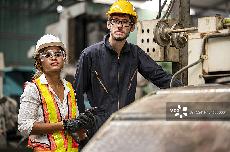 两名工程师在废品分拣厂工作。二手机械商店。图片素材