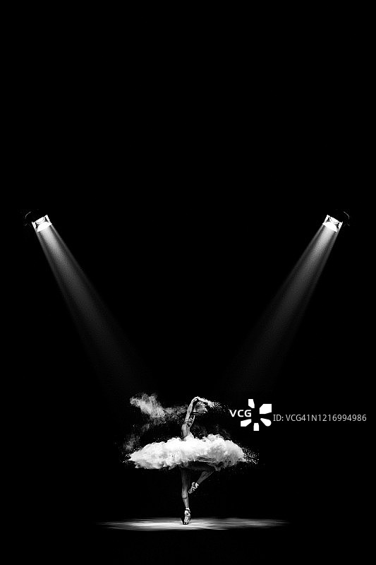 在聚光灯下与灰尘共舞的芭蕾舞演员图片素材