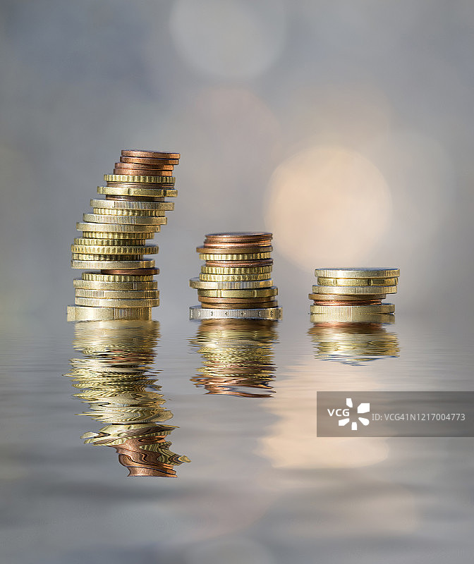 阳光照射并反射在水面上的欧元硬币堆图片素材