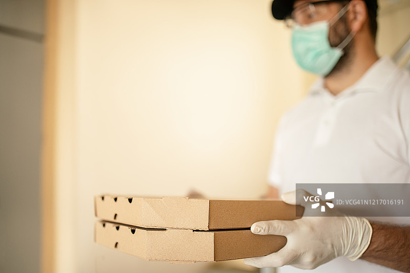 戴防护口罩手套的披萨外卖员图片素材