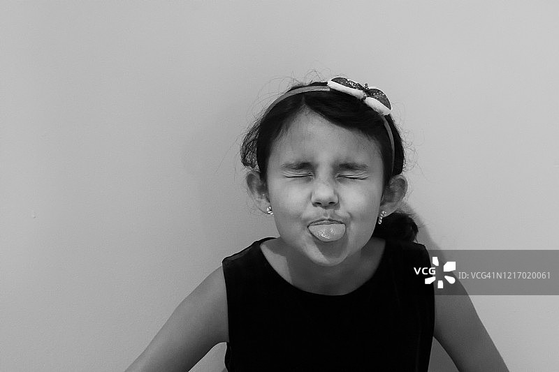 对着镜头做鬼脸的女孩肖像图片素材