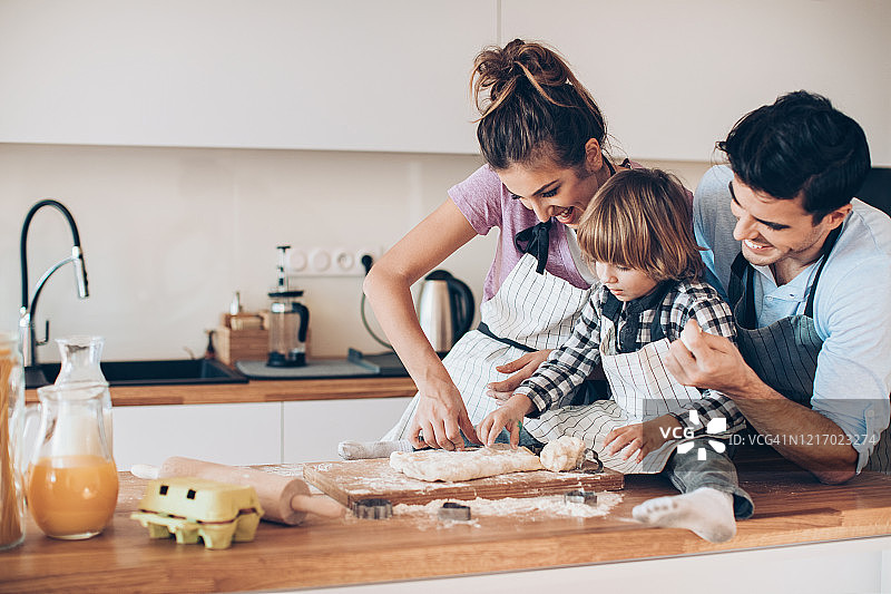 年轻家庭与小孩一起制作饼干图片素材