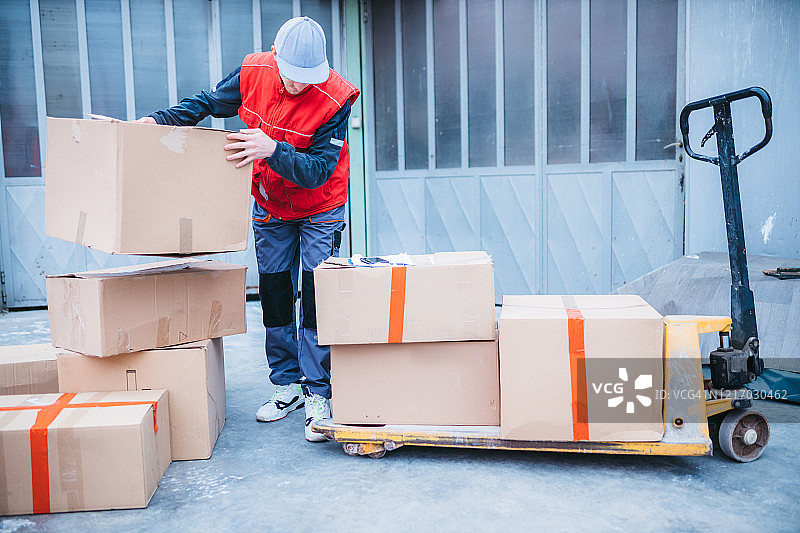 年轻工人赶着将包裹装入送货车图片素材